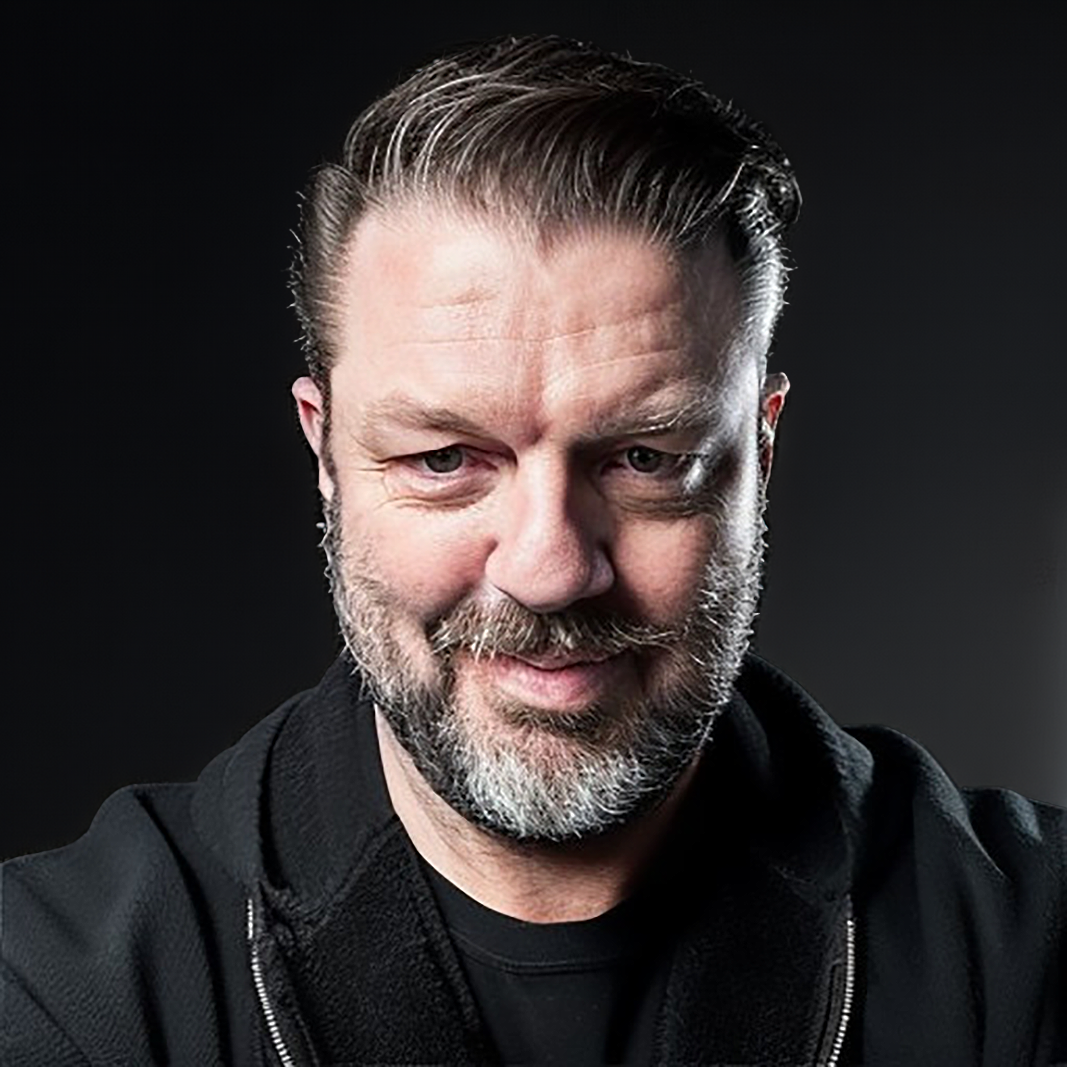 Portrait of Mark Royse in black hoodie against a dark background